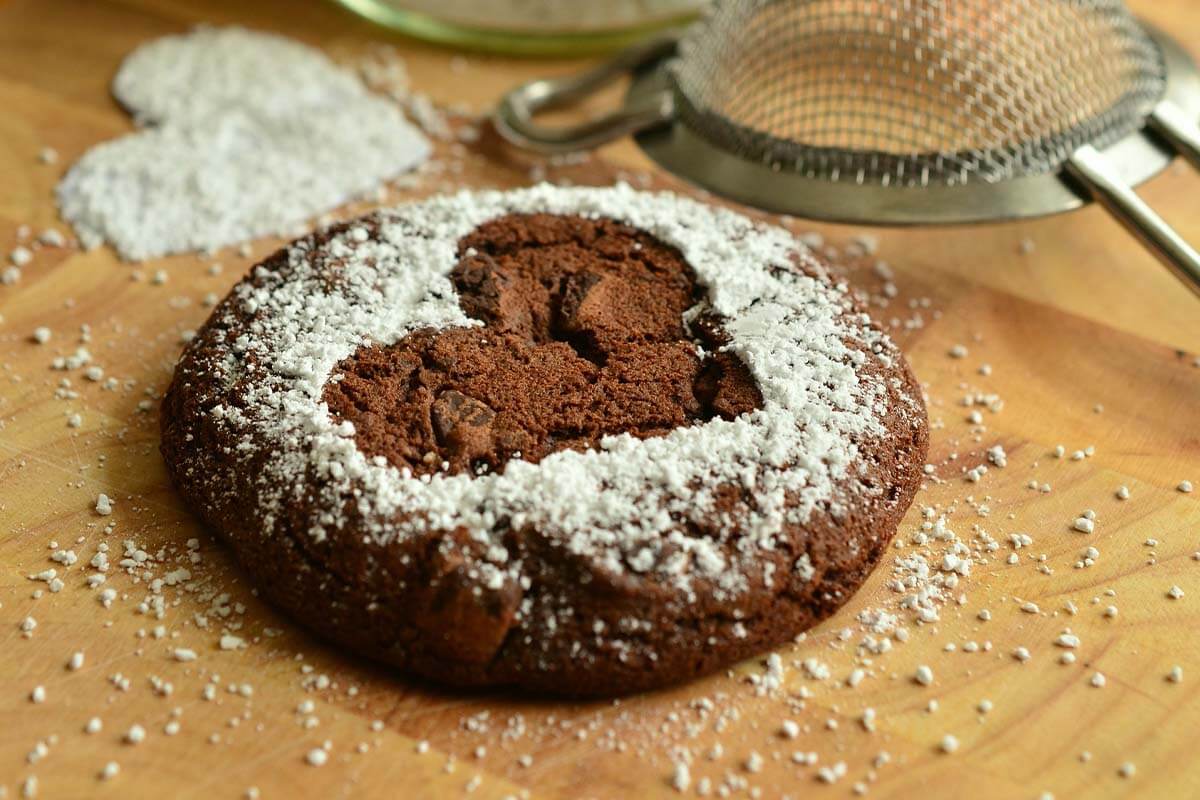 Ein Schokoladen-Cookie mit einem gepuderten Herz.