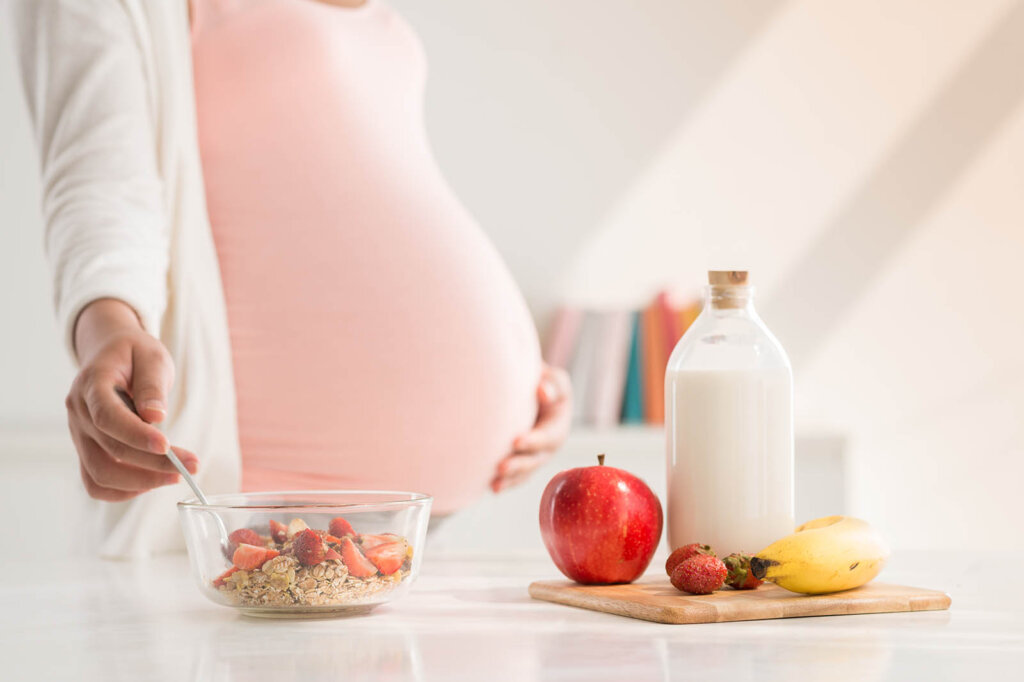 schwangere frau bereitet sich muesli zu