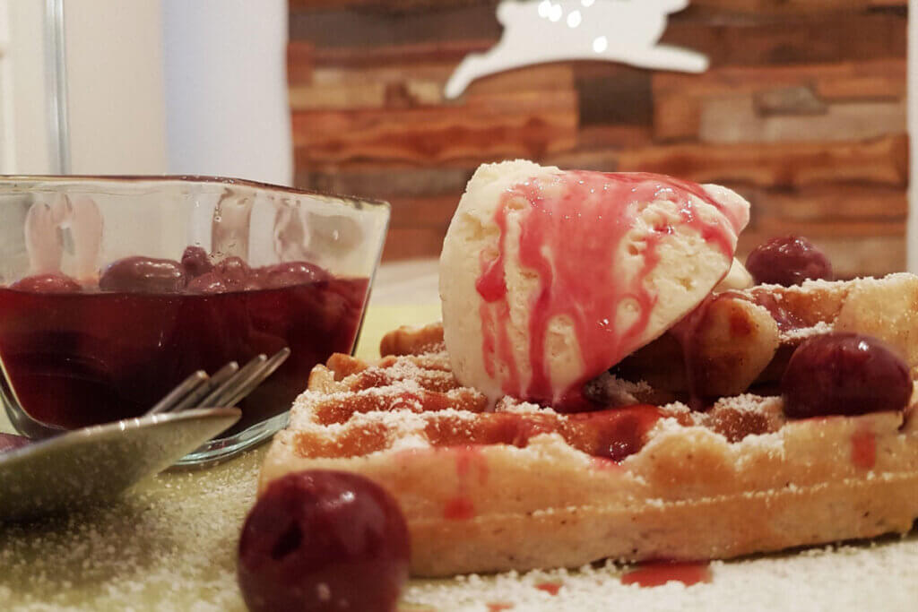 Vegane belgische Waffeln, mit Eis und Kirschen.