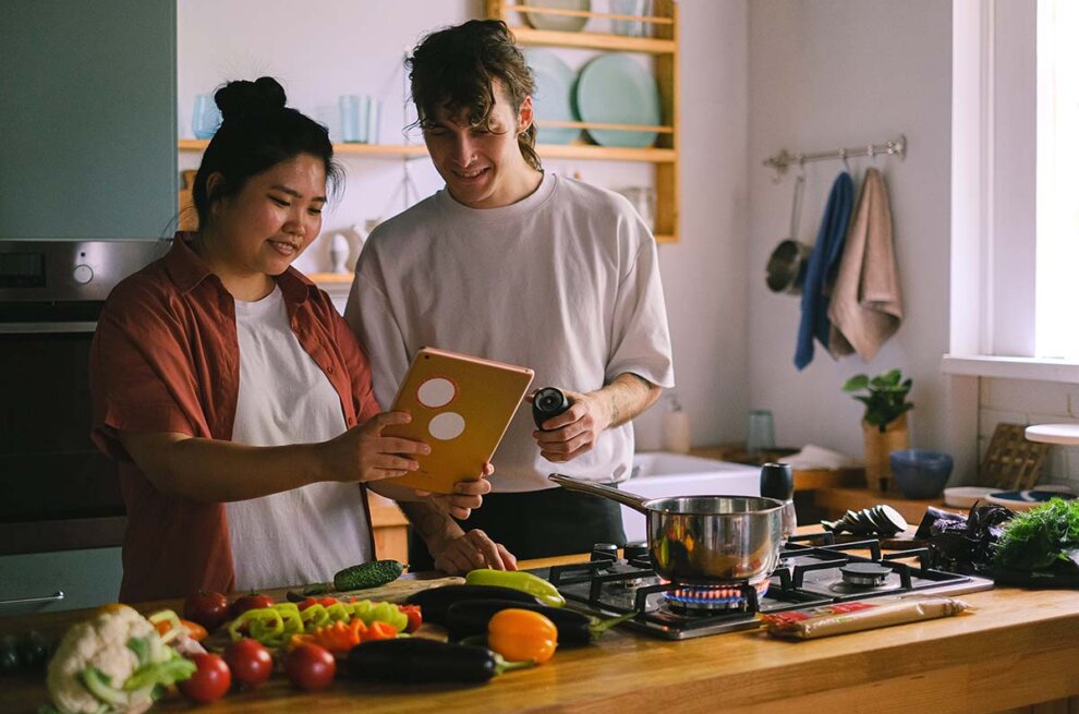 zwei Menschen stehen in der Küche und kochen