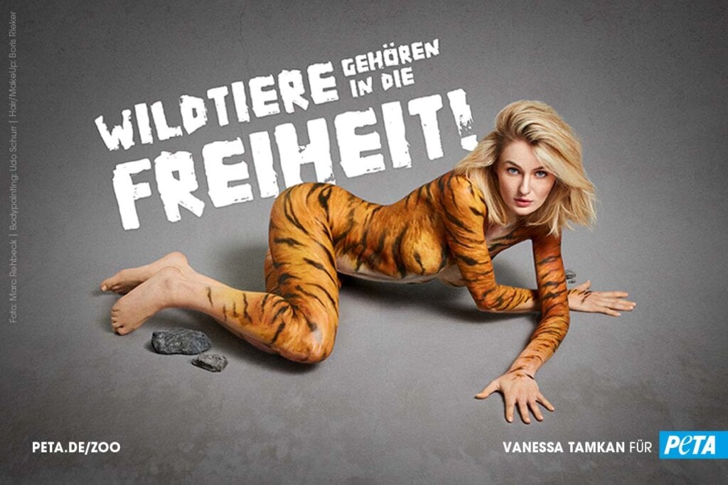 Frau posiert mit Bodypainting gegen WIldtiere in Zoos