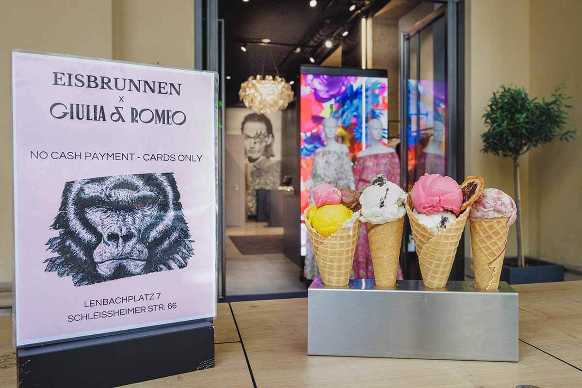 Die vegane Eisdiele Eisbrunnen und die vegane Modemarke Giulia & Romeo haben für ihre Kooperation ein Plakatt und eine Skulptur mit Waffeln und verschiedenen Eissorten vor den Store der Modemarke gestellt.